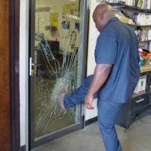 man kicking glass door